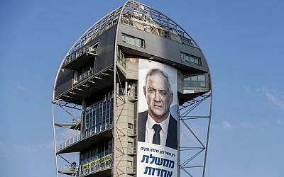 This picture taken on September 10, 2019 shows an electoral banner for the Blue and White alliance showing the face of retired general Benny Gantz and a caption in Hebrew reading "only a big Blue and White will create a secular unity government" hanging from a building in Tel Aviv. (AHMAD GHARABLI / AFP)