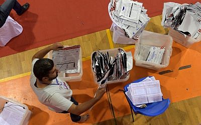 A staff member of Tunisia's Independent Higher Authority for Elections (ISIE) sorts through ballot boxes as they prepare the results of the presidential vote at a sorting center in Ariana, north of the capital Tunis on September 16, 2019 (FETHI BELAID / AFP)