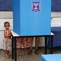 Israeli children accompany their father in a polling booth during Knesset elections at a polling station in Rosh Ha'ayin, on September 17, 2019. (Jack Guez/AFP)
