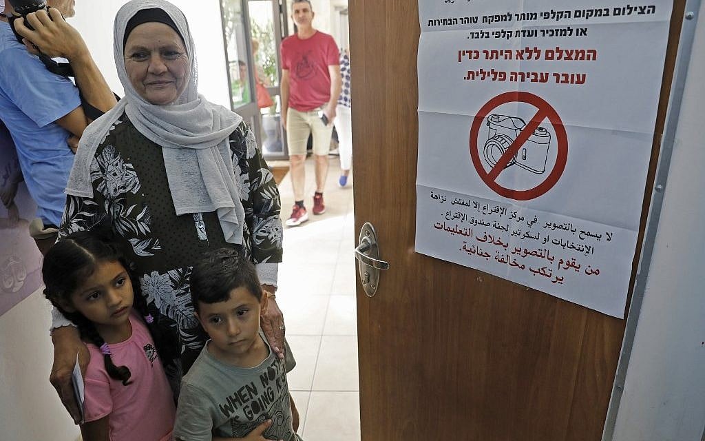 An Arab Israeli woman on election day at a polling station in Haifa,  on September 17, 2019. The sign on the door warns the unauthorized photography is illegal. (Photo by Ahmad GHARABLI / AFP)
