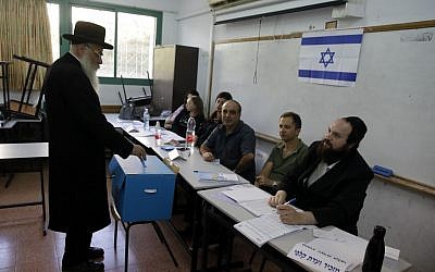 An elderly ultra-Orthodox Jewish man casts his ballot at a voting station in the city of Bnei Brak during the Israeli parliamentary election on September 17, 2019. (Menahem KAHANA/AFP)