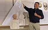Liran Carmel of the Hebrew University reveals a 3D printed model of the face of prehistoric human species Denisovan during a press conference at the Hebrew University in Jerusalem on September 19, 2019. (MENAHEM KAHANA / AFP)