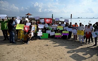 People display placards during a rally as part of a global climate change campaign at Sanur beach on Indonesia's resort island of Bali on September 20, 2019. (SONNY TUMBELAKA / AFP)