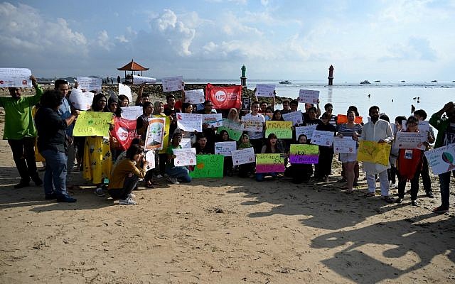 People display placards during a rally as part of a global climate change campaign at Sanur beach on Indonesia's resort island of Bali on September 20, 2019. (SONNY TUMBELAKA / AFP)