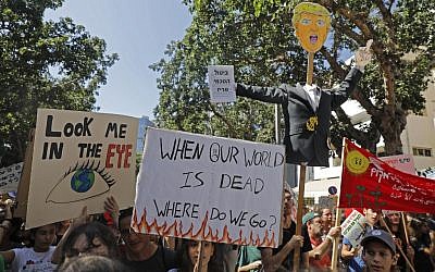 Illustrative: Activists and demonstrators hold placards as they take part in a Global Climate Strike in Tel Aviv on September 27, 2019, against inaction on climate change. (AHMAD GHARABLI / AFP)