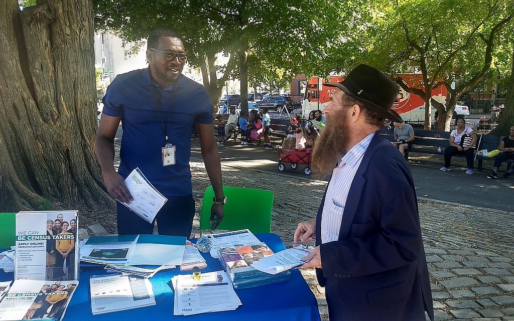 Illustrative: Rabbi Eli Cohen (right), the executive director of the Crown Heights Community Center, talks with a census volunteer at the #OneCrownHeights festival which promotes unity between the Jewish and African-American communities in Brooklyn, New York, on Sunday, September 15, 2019. (Ben Sales/via JTA)