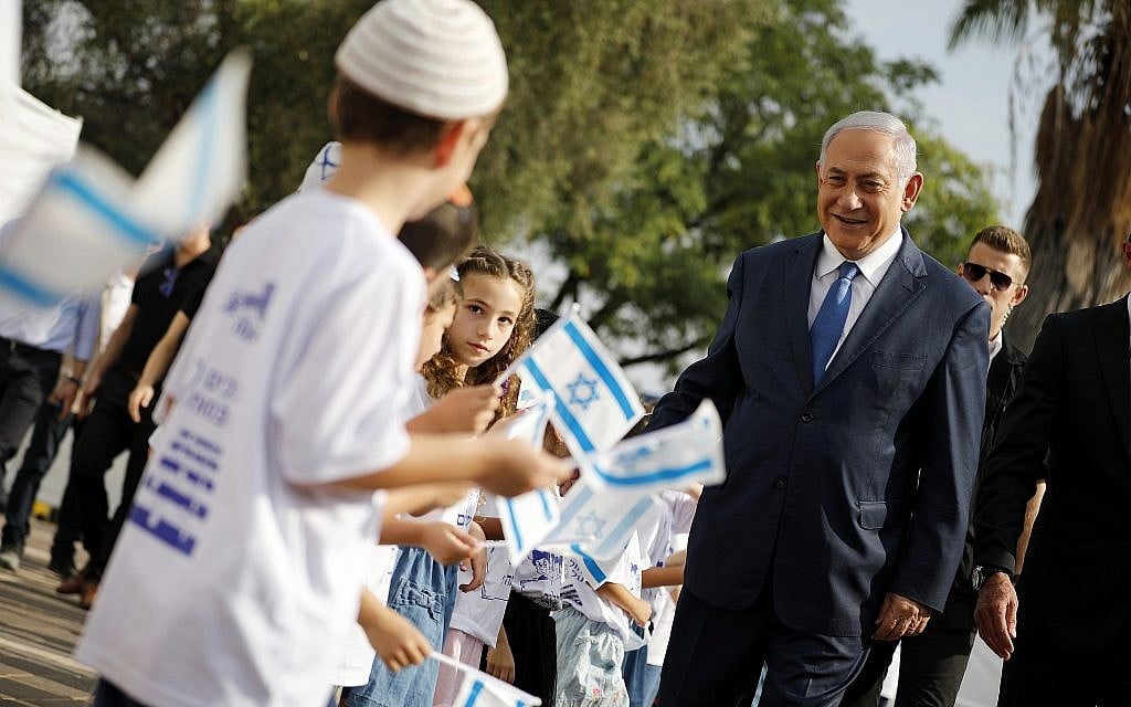 Prime Minister Benjamin Netanyahu, right, greets students as they wave Israeli flags during a ceremony opening the school year in the settlement of Elkana in the West Bank Sunday, Sep. 1, 2019. (Amir Cohen/Pool Photo via AP) Prime Minister Benjamin Netanyahu, right, greets students as they wave Israeli flags during a ceremony opening the school year in the settlement of Elkana in the West Bank Sunday, Sep. 1, 2019. (Amir Cohen/Pool Photo via AP)