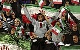 In this photo from October 16, 2018, Iranian women cheer as they wave their country's flag after authorities in a rare move allowed a select group of women into Azadi stadium to watch a friendly soccer match between Iran and Bolivia, in Tehran, Iran. (AP Photo/Vahid Salemi, File)