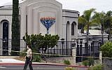 In this April 28, 2019 file photo, a San Diego county sheriff's deputy stands in front of the Poway Chabad Synagogue in Poway, California, following a shooting that left one woman dead and wounded three others. (AP Photo/Denis Poroy, File)