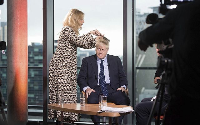 British Prime Minister Boris Johnson has his hair combed as he prepares to appear on a TV political show at Media City in Salford, England, before opening the Conservative party annual conference on September 29, 2019. (Stefan Rousseau/PA via AP) British Prime Minister Boris Johnson has his hair combed as he prepares to appear on a TV political show at Media City in Salford, England, before opening the Conservative party annual conference on September 29, 2019. (Stefan Rousseau/PA via AP)