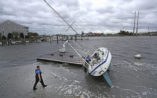 Beaufort Police Officer Curtis Resor, left, and Sgt. Micheal Stepehens check a sailboat for occupants in Beaufort, N.C. after Hurricane Dorian passed the North Carolina coast on Friday, Sept. 6, 2019. (AP Photo/Tom Copeland) Beaufort Police Officer Curtis Resor, left, and Sgt. Micheal Stepehens check a sailboat for occupants in Beaufort, N.C. after Hurricane Dorian passed the North Carolina coast on Friday, Sept. 6, 2019. (AP Photo/Tom Copeland)