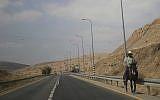 A Palestinian man rides a donkey on a main road in the Jordan Valley, near Tubus, in the West Bank, September 11, 2019. (Ariel Schalit/AP)