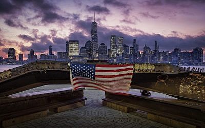 A US flag hanging from a steel girder, damaged in the September 11, 2001, attacks on the World Trade Center, blows in the breeze at a memorial in Jersey City, New Jersey, September 11, 2019, as the sun rises behind One World Trade Center building and the re-developed area where the Twin Towers of World Trade Center once stood in New York City on the 18th anniversary of the attacks. (AP Photo/J. David Ake) A US flag hanging from a steel girder, damaged in the September 11, 2001, attacks on the World Trade Center, blows in the breeze at a memorial in Jersey City, New Jersey, September 11, 2019, as the sun rises behind One World Trade Center building and the re-developed area where the Twin Towers of World Trade Center once stood in New York City on the 18th anniversary of the attacks. (AP Photo/J. David Ake)