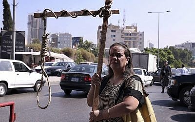 A former inmate of Khiam prison holds a mock gallows during a sit-in near a military court where an arrest warrant was issued for Lebanese-American Amer Fakhoury, who confessed he had worked for Israel when it had a security zone in Lebanon for nearly two decades, in Beirut, Lebanon, September 17, 2019. (Bilal Hussein/AP)
