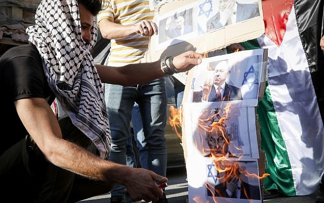 Palestinians burn pictures depicting Israeli Prime Minister Benjamin Netanyahu during a protest against the PM's visit to the West Bank city of Hebron, September 4, 2019 (Wisam Hashlamoun/Flash90) Palestinians burn pictures depicting Israeli Prime Minister Benjamin Netanyahu during a protest against the PM's visit to the West Bank city of Hebron, September 4, 2019 (Wisam Hashlamoun/Flash90)