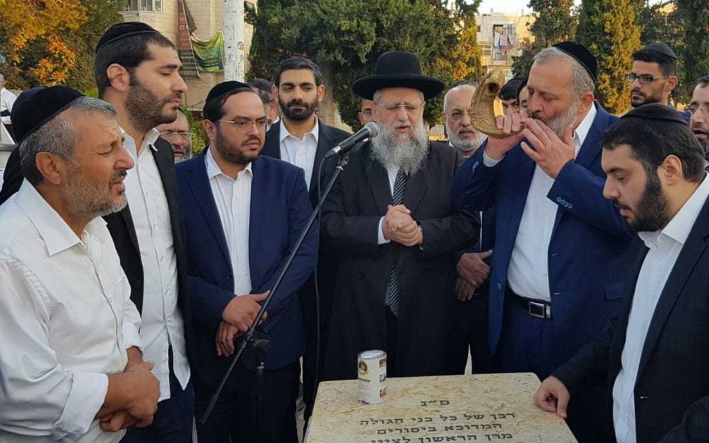 Shas leader Aryeh Deri, second right, blows a shofar at the grave of Rabbi Ovadia Yosef on September 17, 2019. (Yaakov Cohen/Shas)