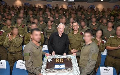 Members of the IDF Commando Brigade present President Reuven Rivlin with a cake at a surprise birthday party on Monday. (Mark Neiman/GPO)