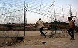Illustrative: Palestinians illegally cross the border fence into Israel on the outskirts of the West Bank city of Hebron, August 6, 2019. (Wisam Hashlamoun/Flash90)