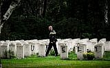 A police officer walks past graves which have been vandalized with graffiti in the British World War II Commonwealth Graves cemetery in Mierlo, east of Eindhoven, Netherlands, September 13, 2019. (Rob Engelaar/ANP/AFP)