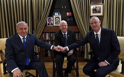 Prime Minister Benjamin Netanyahu (L) shakes hands with Blue and White party leader Benny Gantz (R) as President Reuven Rivlin looks on, at the President's Residence in Jerusalem, on September 23, 2019. (Haim Zach/GPO)