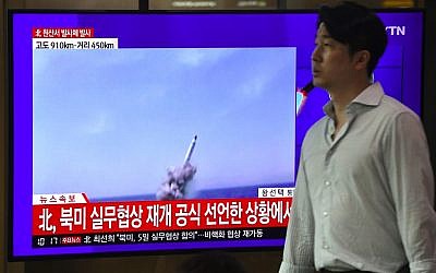 A man walks past a television news screen showing file footage of a North Korean missile launch, at a railway station in Seoul on October 2, 2019. (Jung Yeon-je / AFP)