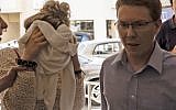 A British teenager (L), accused of falsely claiming she was gang raped by Israeli tourists, covering her face as she arrives for her trial at the Famagusta District Court in Paralimni in eastern Cyprus, October 2, 2019. (Iakovos HATZISTAVROU/AFP)