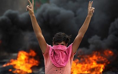 An Iraqi protester flashes the v-sign during a demonstration against state corruption, failing public services and unemployment in the Baladiyat district of the capital Baghdad on October 2, 2019 (AHMAD AL-RUBAYE / AFP) An Iraqi protester flashes the v-sign during a demonstration against state corruption, failing public services and unemployment in the Baladiyat district of the capital Baghdad on October 2, 2019 (AHMAD AL-RUBAYE / AFP)