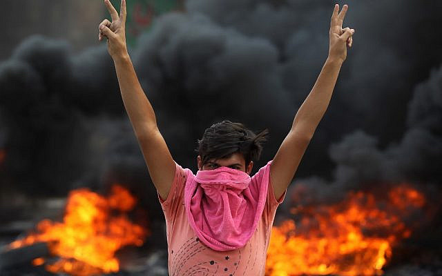 An Iraqi protester flashes the v-sign during a demonstration against state corruption, failing public services and unemployment in the Baladiyat district of the capital Baghdad on October 2, 2019 (AHMAD AL-RUBAYE / AFP) An Iraqi protester flashes the v-sign during a demonstration against state corruption, failing public services and unemployment in the Baladiyat district of the capital Baghdad on October 2, 2019 (AHMAD AL-RUBAYE / AFP)