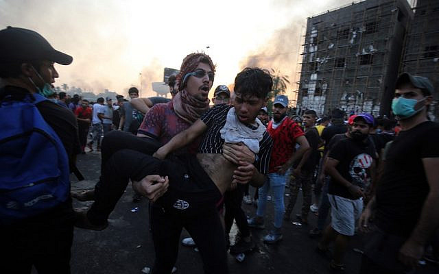 An Iraqi protester carries a wounded comrade during a demonstration against state corruption, failing public services and unemployment at Tayaran square in Baghdad on October 2, 2019. (AHMAD AL-RUBAYE/AFP) An Iraqi protester carries a wounded comrade during a demonstration against state corruption, failing public services and unemployment at Tayaran square in Baghdad on October 2, 2019. (AHMAD AL-RUBAYE/AFP)