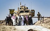 Syrian Kurds take part in a demonstration against Turkish threats at a US-led international coalition base on the outskirts of Ras al-Ain town, in Syria's Hasakeh province near the Turkish border, on October 6, 2019.  (Delil SOULEIMAN / AFP)