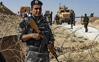 A member of Kurdish security forces stands guard during a demonstration by Syrian Kurds against Turkish threats next to a base for the US-led international coalition on the outskirts of Ras al-Ain town in Syria's Hasakeh province near the Turkish border on October 6, 2019. (Delil SOULEIMAN / AFP)
