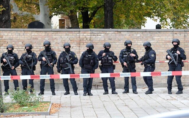 Policemen stand in front of a wall of the Jewish cemetery close to the site of a shooting in Halle an der Saale, eastern Germany, on October 9, 2019 (Sebastian Willnow / dpa / AFP) / Germany OUT Policemen stand in front of a wall of the Jewish cemetery close to the site of a shooting in Halle an der Saale, eastern Germany, on October 9, 2019 (Sebastian Willnow / dpa / AFP) / Germany OUT