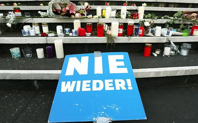 A poster reading "Never again," flowers and candles are placed at a makeshift memorial in front of the synagogue in Duesseldorf, western Germany, on October 10, 2019, one day after the deadly anti-Semitic shooting in Halle. (David Young/DPA/AFP) A poster reading "Never again," flowers and candles are placed at a makeshift memorial in front of the synagogue in Duesseldorf, western Germany, on October 10, 2019, one day after the deadly anti-Semitic shooting in Halle. (David Young/DPA/AFP)