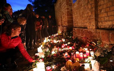 Mourners light candles on October 10, 2019, at the synagogue in Halle, eastern Germany, one day after a deadly anti-Semitic shooting. (Ronny Hartmann/AFP)