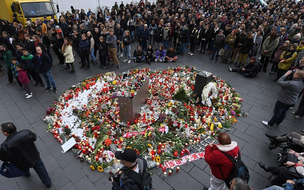 Participants gather around a makeshift memorial for the victims of a deadly shooting during an attack targeting a Turkish restaurant after an attempt at a synagogue on October 11, 2019 in Halle. (Photo by Hendrik Schmidt / dpa / AFP) / Germany OUT