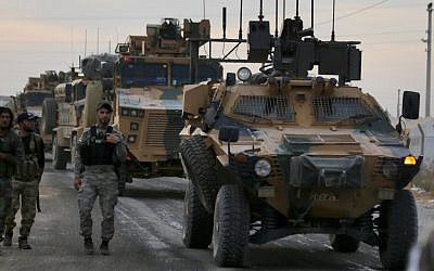Turkish-backed Syrian fighters walk next to Turkish army vehicles near the village of Akcakale along the border with Syria on October 11, 2019, as they prepare to take part in the Turkish-led assault on northeastern Syria. (Bakr Alkasem/AFP)