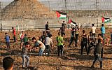 Palestinians riot by the border fence between the Gaza Strip and Israel, east of Gaza City, on October 11, 2019. (Said Khatib/AFP)
