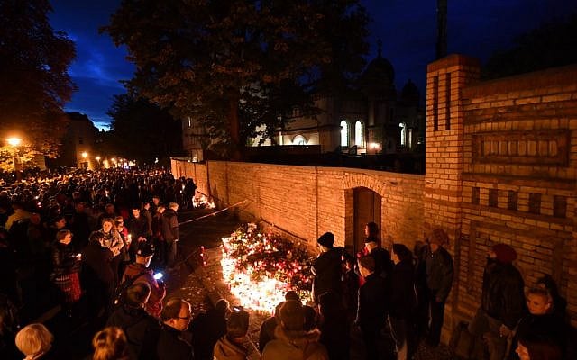 Mourners stand around a makeshift memorial of candles and flowers at the synagogue in Halle, eastern Germany, on October 11, 2019, two days after a deadly shooting. (Photo by Hendrik Schmidt / dpa / AFP) / Germany OUT Mourners stand around a makeshift memorial of candles and flowers at the synagogue in Halle, eastern Germany, on October 11, 2019, two days after a deadly shooting. (Photo by Hendrik Schmidt / dpa / AFP) / Germany OUT