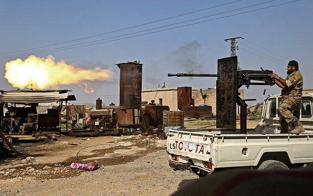 A Turkish-backed Syrian fighter fires during clashes in the border town of Ras al-Ain on October 13, 2019, as Turkey and its allies continue their assault on Kurdish-held border towns in northeastern Syria. (Nazeer Al-khatib / AFP) A Turkish-backed Syrian fighter fires during clashes in the border town of Ras al-Ain on October 13, 2019, as Turkey and its allies continue their assault on Kurdish-held border towns in northeastern Syria. (Nazeer Al-khatib / AFP)
