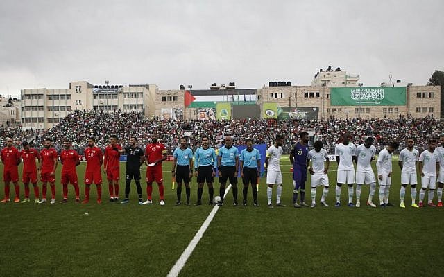 The Saudi and Palestinian national football teams listen to their national anthems during a World Cup 2022 Asian qualifying match between Palestine and Saudi Arabia in the town of al-Ram in the West Bank on October 15, 2019. (HAZEM BADER/AFP)