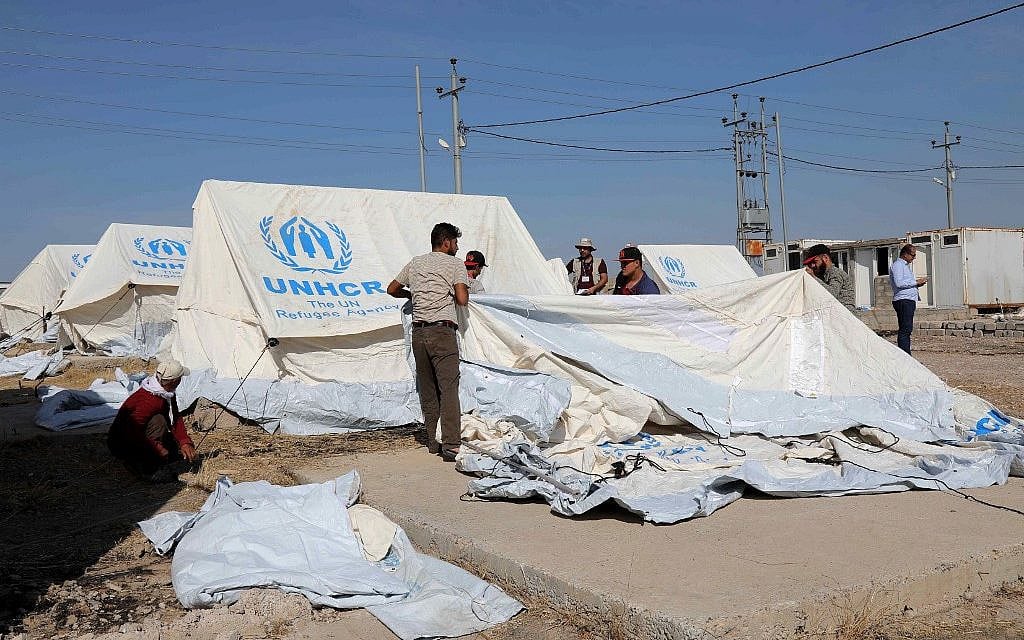 Workers set tents in preparation to receive Syrian refugees who have been newly displaced by the Turkish military operation in northeastern Syria, at the Bardarash camp, near the city of Dohuk, in Iraq's autonomous Kurdish region, on October 16, 2019. (SAFIN HAMED / AFP)