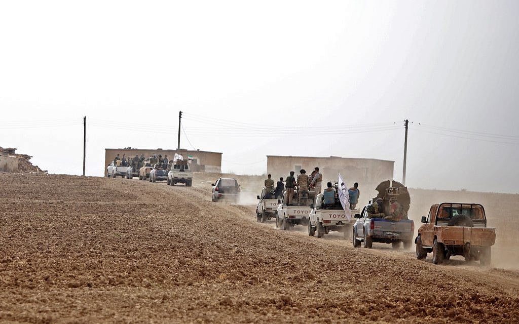 A convoy of pickup trucks transports Turkey-backed Syrian fighters on the road between Tal Abyad and Kobane on October 16, 2019 as Turkey continues its assault on Kurdish-held border towns in northeastern Syria. (Bakr ALKASEM / AFP)