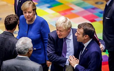 British Prime Minister Boris Johnson (2nd R) embraces French President Emmanuel Macron (R) upon their arrival for a round table meeting as part of a European Union summit at European Union Headquarters in Brussels on October 17, 2019. (Olivier Matthys / POOL / AFP)