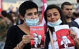 Women wave signs reading "leave" in Arabic and showing the faces of Lebanon's President Michel Aoun, Prime Minister Saad Hariri, and Parliament Speaker Nabih Berri, during a protest outside the presidential palace in Baabda, east of the capital Beirut, on October 18, 2019.  (Anwar Amro/AFP)