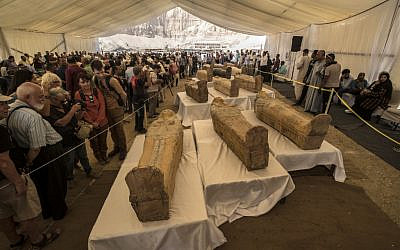 Tourists observe sarcophagi displayed in front of Hatshepsut Temple in Egypt's valley of the Kings in Luxor on October 19, 2019. (Photo by Khaled DESOUKI / AFP)