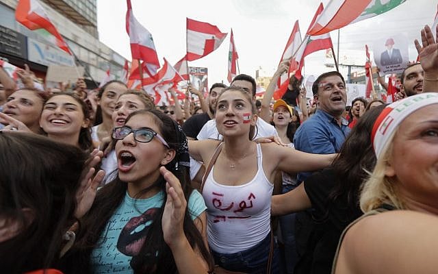Lebanese demonstrators wave national flags on a highway linking Beirut to north Lebanon, in Zouk Mosbeh on October 19, 2019, a day after demonstrations swept through the eastern Mediterranean country in protest against dire economic conditions. (JOSEPH EID / AFP) Lebanese demonstrators wave national flags on a highway linking Beirut to north Lebanon, in Zouk Mosbeh on October 19, 2019, a day after demonstrations swept through the eastern Mediterranean country in protest against dire economic conditions. (JOSEPH EID / AFP)