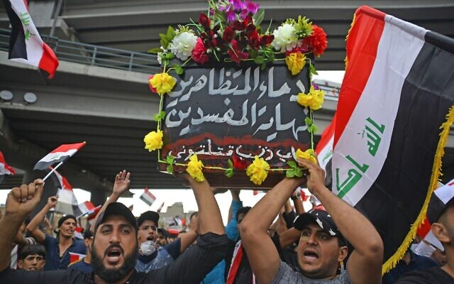 Iraqi protesters march with a symbolic coffin representing their country and bearing the Arabic words "the blood of the demonstrators is the end of the corrupt, for what sin have you killed me?" as they march during an anti-government demonstration in the central holy shrine city of Najaf on October 25, 2019. (AFP) Iraqi protesters march with a symbolic coffin representing their country and bearing the Arabic words "the blood of the demonstrators is the end of the corrupt, for what sin have you killed me?" as they march during an anti-government demonstration in the central holy shrine city of Najaf on October 25, 2019. (AFP)
