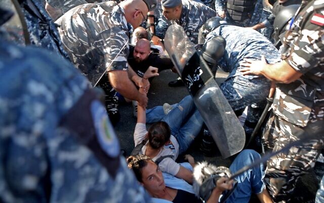Lebanese riot police officers remove anti-government protesters as they dismantle a roadblock in the centre of the Lebanese capital Beirut on October 31, 2019 (Patrick BAZ / AFP)