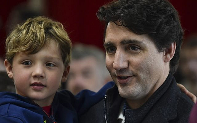 Canadian Prime Minister Justin Trudeau, accompanied by his youngest son Hadrien Trudeau, waits in line to cast his vote on election day at a polling station on October 21, 2019 in Montreal, Canada. (Minas Panagiotakis/Getty Images/AFP)