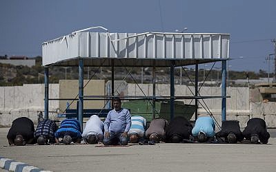 In this photo from March 26, 2017, Palestinian residents of the Gaza Strip pray as they wait on the Israeli side of the Erez terminal to cross into Gaza. (AP Photo/Tsafrir Abayov, File)